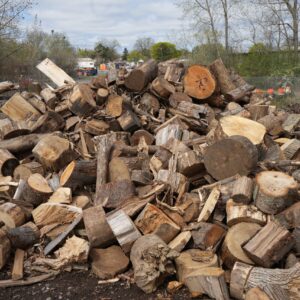 A large pile of chopped firewood. Firewood stacked outdoors.